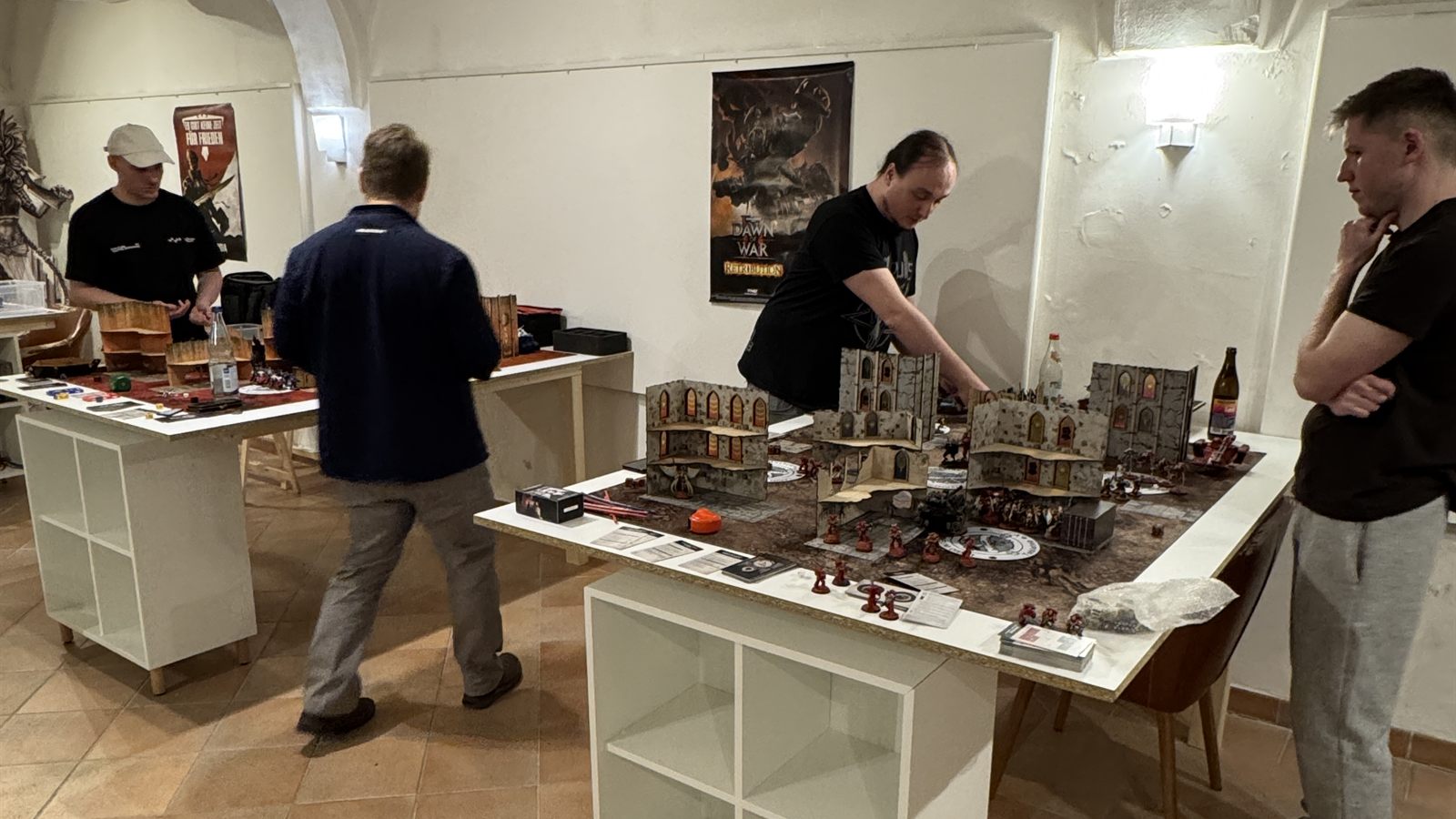 Mitglieder an aufgebauten Tabletop-Spieltischen mit Gelände und Miniaturen beim Clubabend der Legio Intermeratus in Augsburg